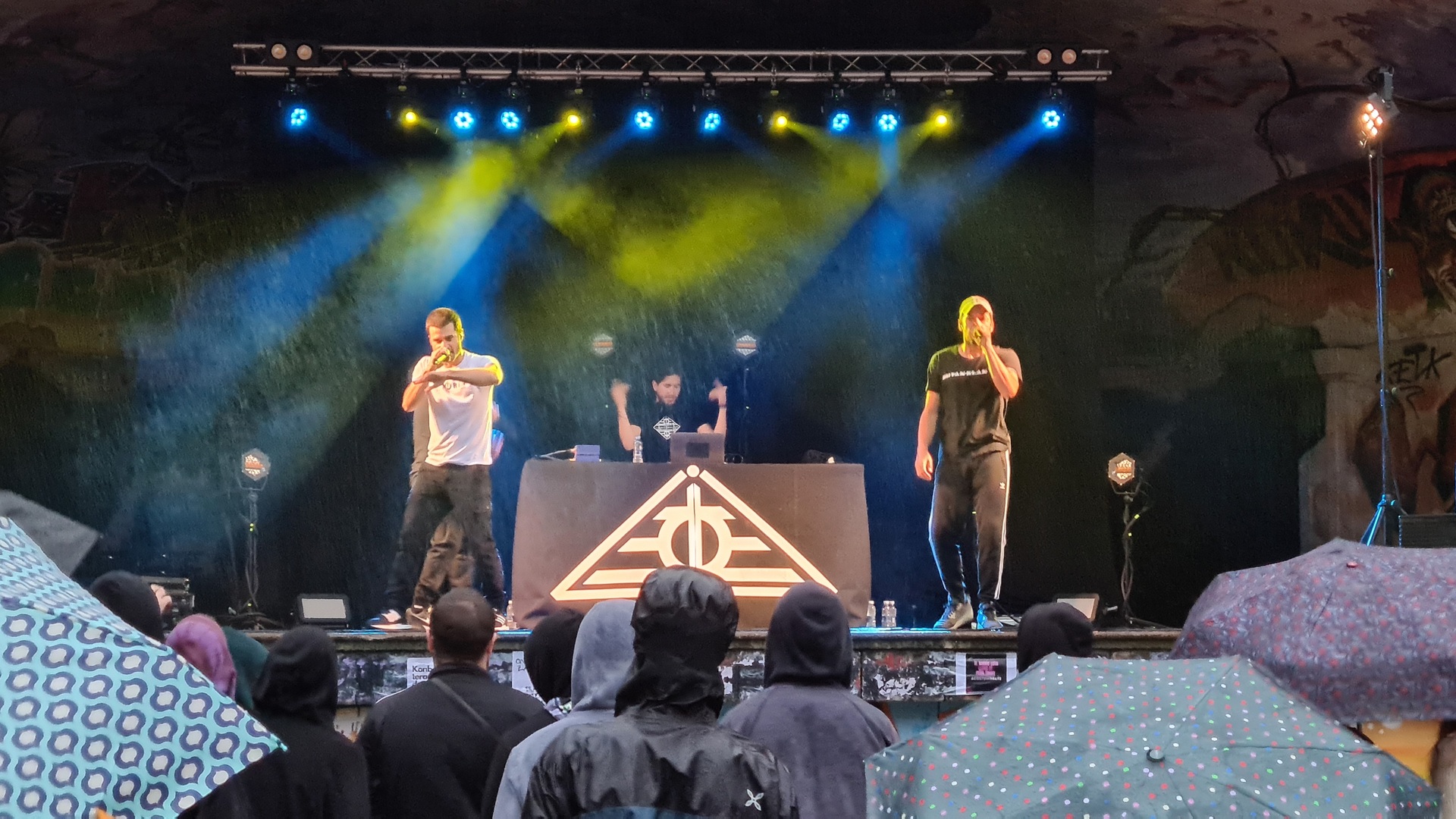 Un concierto de dos chicos cantando y otro chico con la música